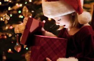 lITTLE GIRL LOOKING INSIDE A WRAPPED PRESENT